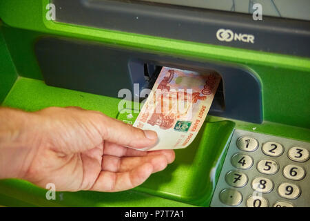 Syzran, Russia - June 20 , 2018: finance, money, bank and people concept - close up of hand taking receipt from atm machine of the Sberbank Stock Photo