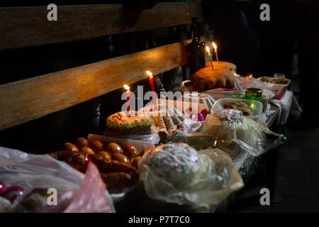 Easter cakes and pies with candles in wicker baskets, ready for lighting with holy water Stock Photo