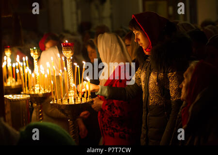 Belarus, Gomel, on April 8, 2018. The Nikolsky Monastery. The celebration of Orthodox Easter. A woman in the church lights a candle. Stock Photo