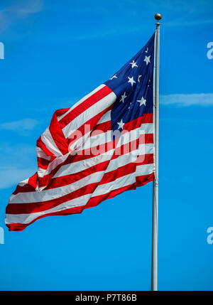 A photograph of a very large American Flag flying high on the beautiful day. Stock Photo
