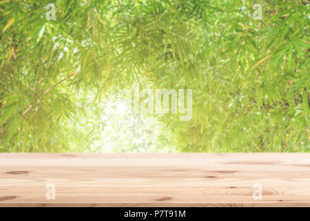 blur green nature bamboo leaf with wooden table for display in natural eco friendly product background. Stock Photo