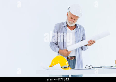 Senior serious construction engineer with hard hat hand holding blueprint in studio with white space for text Stock Photo