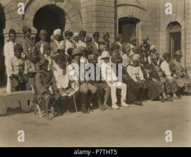 English: Official photograph taken on the occasion of the Lahej Conference of 1930, the first meeting ever between a Resident of Aden (then Sir Stewart Symes, center) and the main tribal chiefs and rulers of the Western Protectorate. To the left of Sir Symes is Sultan Abdul Karim Fadhl of Lahej, the most important state of the Western Protectorate. To the left of Sultan Fadhl is the Amir of Dhala, a strategic state bordering on Yemen (then the Imamate of Yemen). The other European in the front row is Bernard R. Reilly, then Assistant Resident. Reilly, who had been serving in Aden since 1912, w Stock Photo