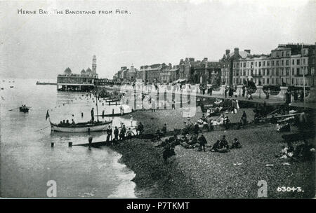 Postcard showing a print of Herne Bay (Kent, England) looking east from the third Herne Bay Pier. The original photo was probably taken from the promenade deck halfway up the Grand Pier Pavilion, or possibly from the roof of the entrance building. This shows a special aspect of the pier, which was to give an unusual view of the town from the sea, for those who had no access to ships. The bandstand can be seen along the beach. It was published by Photochrom of London and Tunbridge Wells. 1924-1929 (Reason for date: 1924 first phase of bandstand is visible; 1932 second phase not yet visible; 192 Stock Photo