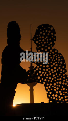 Berlin, Germany. 02nd July, 2018. The large sculpture Molecule Man by American artist Jonathan Borofsky glows orange in the sunset. Credit: Paul Zinken/dpa/Alamy Live News Stock Photo