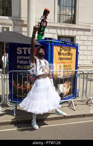 London, UK. 7th July 2018. A man in a white skirt holding a water gun in the air at Pride in London 2018 Parade, joining more than 1 million attending the march today to celebrate LGBT+. Credit: Dimple Patel/Alamy Live News Stock Photo