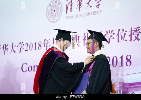 Beijing, China. 8th July, 2018. President of Tsinghua University Qiu Yong (L) arranges academic dress for a graduate during the 2018 commencement ceremony of Tsinghua University held in Beijing, capital of China, July 8, 2018. Over 3,000 graduates attended the ceremony on Sunday. Credit: Ju Huanzong/Xinhua/Alamy Live News Stock Photo