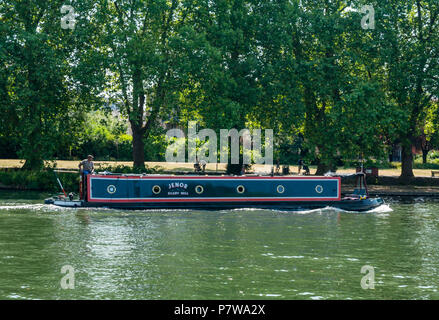 River Thames, Hampton Wick, London, England, United Kingdom, 8th July 2018. UK weather: people enjoy themselves on the Thames River on a Sunday morning in the heatwave. A houseboat passes by Stock Photo