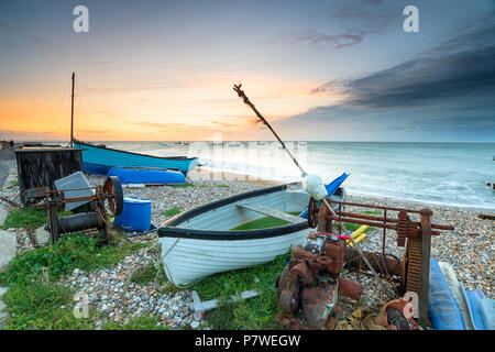 Stormy sunrise over boats on the beach at Selsey Bill on the Sussex coast Stock Photo