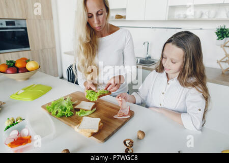 Mother with daughter preparing school lunch in home kitchen Stock Photo