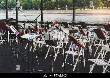 Classical music background. Different musical instruments on the river bank in a warm summer evening Stock Photo