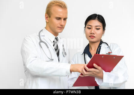 Doctor and assistant nurse checking patient laboratory test. Two hospital workers discussing on checking result list. Medical and Healthcare concept.  Stock Photo