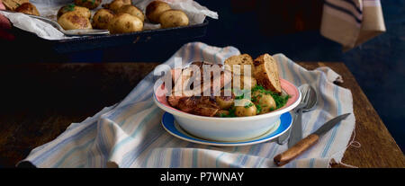 Plate with fresh fried potatoes and meat on a wooden table. Rustic style Stock Photo