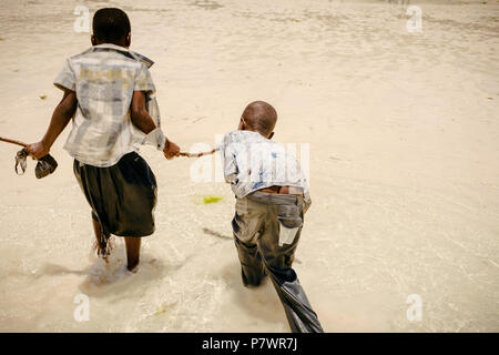 African childs in search of seafood in the ocean Stock Photo