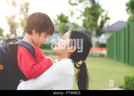 Mom hug and carry her son. Preparing to send her children back to school in morning. Education and Back to school concept. Happy family and Loving of  Stock Photo