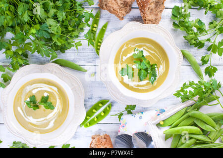 Cream soup with green peas and fresh herbs. Spring dinner. Healthy diet . Soup from vegetables. Free space for text. Stock Photo