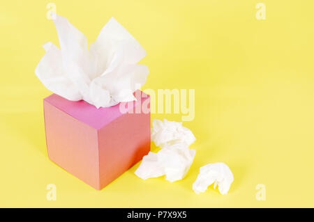 Paper tissues in blank pink box on a yellow background. Stock Photo