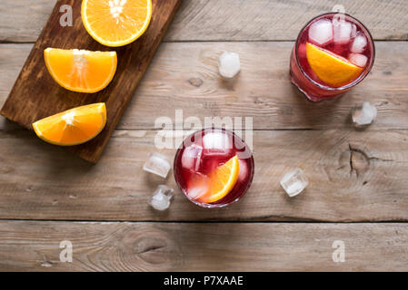 Negroni Cocktail with orange and ice. Homemade Classic Negroni cocktail and ingredients on wooden table, copy space. Stock Photo
