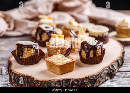 Different cakes standing on a wooden board Stock Photo