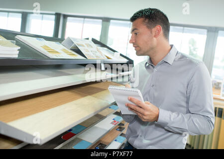 handyman selecting timber from a rack in a hardware Stock Photo