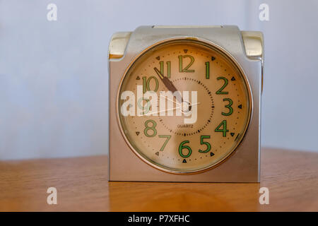 Antique alarm clock on a plain background.  Luminous numbers and classic style. Stock Photo