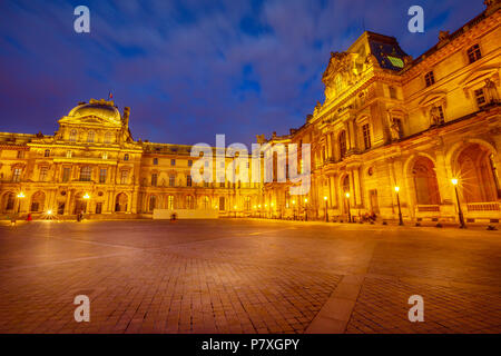 Paris, France - July 1, 2017: Facade of Louvre Art Museum in Cour Napoleon illuminated at evening. The Louvre Museum is one of the world's largest museums. Famous landmark in Paris Capital. Stock Photo