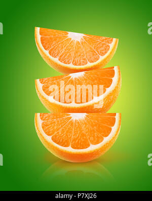 Three pieces of orange fruit on top of each other over green background with clipping path Stock Photo