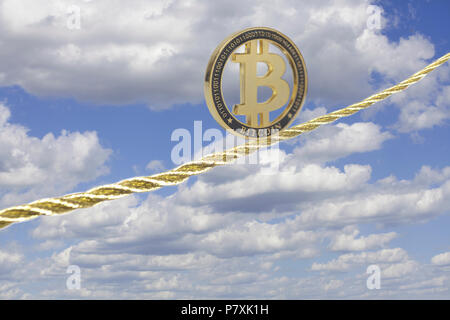 Bitcoin balancing on golden rope in the sky. Stock Photo