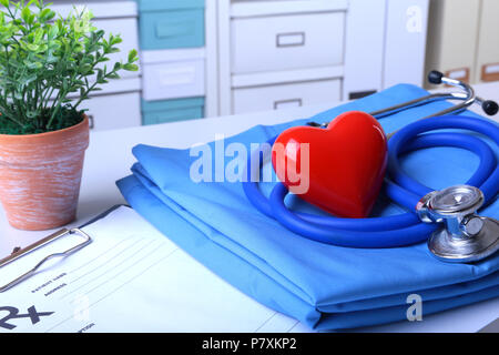 A medical stethoscope with red heart and RX prescription are lying on a medical uniform Stock Photo