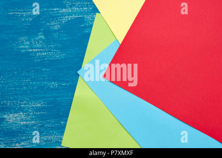 Colored sheets of paper on a wooden painted blue background. Graphic design copy space Stock Photo