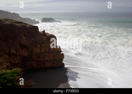 Steep cliffs overlooking beach on sunny day Stock Photo