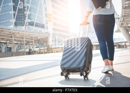 Woman traveler tourist walking with luggage at terminal station. Activity and lifestyle concept. Business people and long holiday vacation theme. Back Stock Photo