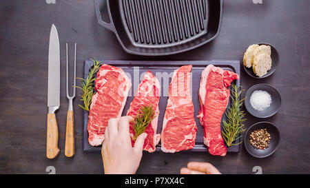 Raw New York strip steaks in cast iron frying pan. Stock Photo