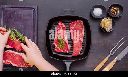 Raw New York strip steaks in cast iron frying pan. Stock Photo