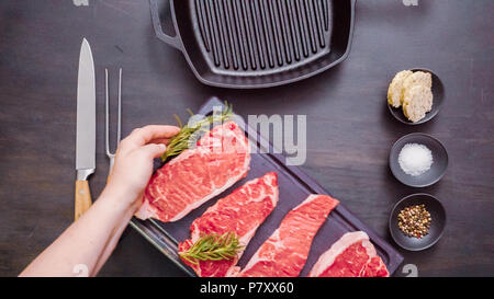 Raw New York strip steaks in cast iron frying pan. Stock Photo