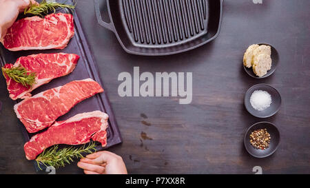 Raw New York strip steaks in cast iron frying pan. Stock Photo