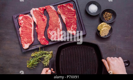 Raw New York strip steaks in cast iron frying pan. Stock Photo