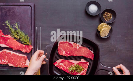 Raw New York strip steaks in cast iron frying pan. Stock Photo