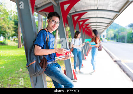 College young Asian students tutoring and reading book at walkway in university. School and friendship theme. Education and graduation concept. Glasse Stock Photo