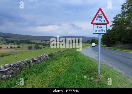 A country road sign warning drivers about the potential of slippery road surfaces in the Bainbridge area of the Yorkshire Dales National Park. Stock Photo