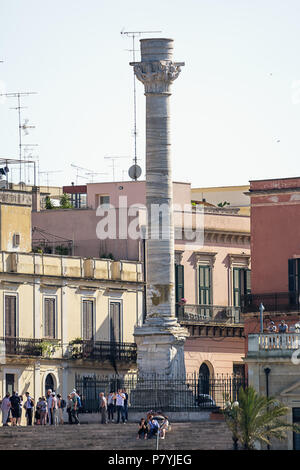 Brindisi, Italy - April 30, 2018: Terminal columns of the ancient Via Appia that begins in Rome and ends in Brindisi (Italy) and tourists visiting Stock Photo