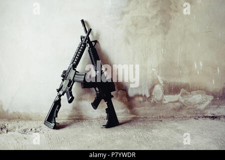 Rifle guns on grunge wall in abandoned house. Terrorist and Soldier concept. Robber and Police concept. War machine gun theme. Stock Photo