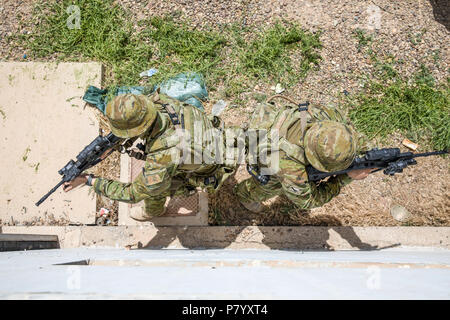 Australian soldiers, with Task Group Taji’s quick reaction force, demonstrate building clearance drills during concurrency training with U.S. Soldiers of Bandit Troop, 3rd Calvary Regiment at Camp Taji, Iraq, June 11, 2018. A Coalition created from a diverse international community will continue its support to the people of Iraq in order to enhance the capabilities of the nation to ensure security and stability. (U.S. Army photo by Spc. Audrey Ward) Stock Photo