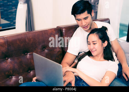 Asian young couples using laptop. Lovers and Couples concept. Honeymoon and Wedding theme. Interior and Dating theme. Stock Photo