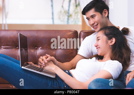 Asian young couples using laptop. Lovers and Couples concept. Honeymoon and Wedding theme. Interior and Dating theme. Stock Photo