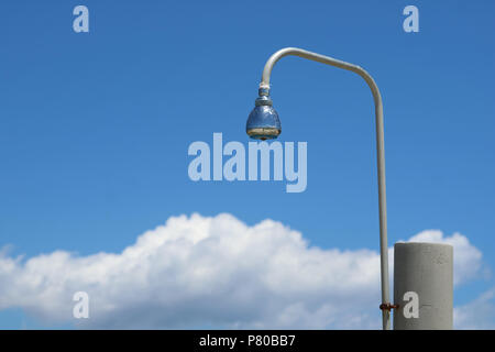 outdoor showering shower head against blue sky with clouds at beach Stock Photo