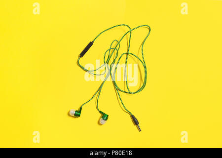 green earphones on a yellow background Stock Photo