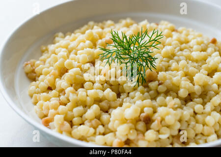 Cooked Couscous with Dill served in White Plate / Turkish Kuskus. Traditional Organic Food. Stock Photo