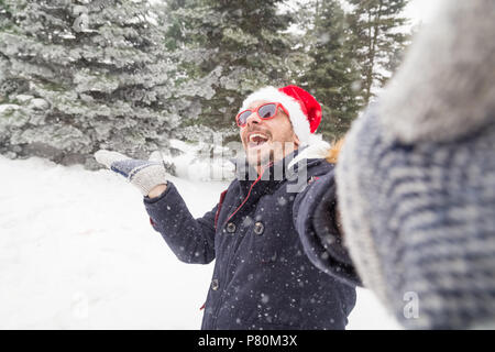 Young fashionable man taking self portrait in forest. Winter scene. Stock Photo