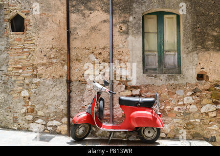 Red Vespa scooter with an histiric building in Sicily, Italy Stock Photo